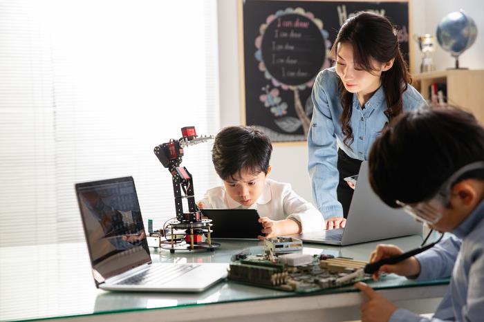 小学生正在学习利用AI操纵机械。（图源：视觉中国）